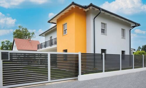 Aluzaun auf Sockel an der Straßenseite eines Einfamilienhauses 