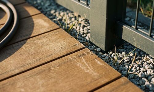 Übergang von den Terrassendielen zum Zaunpfosten im Detail. Der Übergang entscheidet: Wo Diele, Kiesstreifen und Pfosten aufeinandertreffen, sieht man, ob zusammen geplant wurde