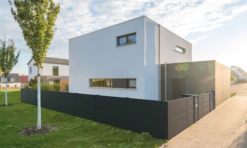 Dunkler Sichtschutzzaun aus Aluminium an einem modernen Einfamilienhaus 